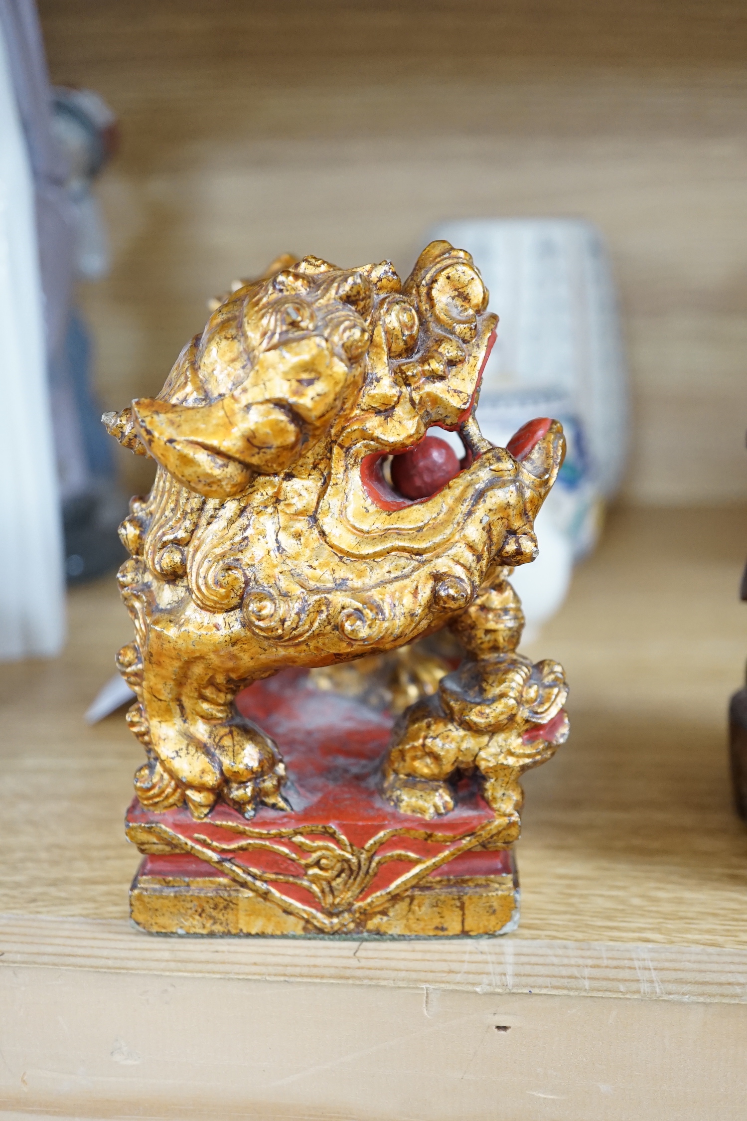 A Chinese lacquered wood figure of a seated woman and a Buddhist lion, tallest 20.5cm